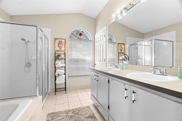 bathroom featuring tile patterned flooring, vanity, vaulted ceiling, and separate shower and tub