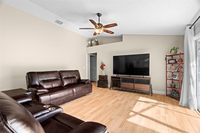 living room featuring hardwood / wood-style floors, vaulted ceiling, a textured ceiling, and ceiling fan