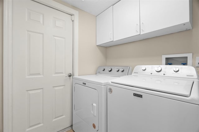 laundry room featuring cabinets and washing machine and clothes dryer