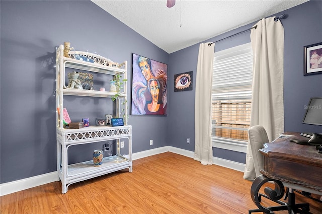 office space with hardwood / wood-style flooring, vaulted ceiling, a textured ceiling, and ceiling fan