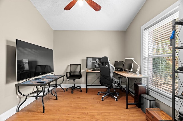 office featuring ceiling fan, vaulted ceiling, a textured ceiling, and light hardwood / wood-style floors