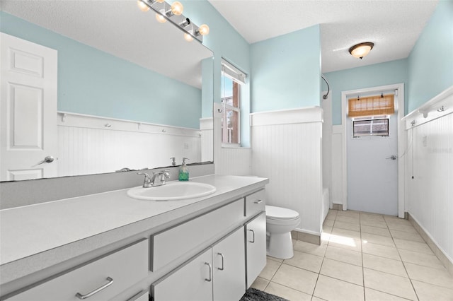 bathroom featuring vanity, tile patterned floors, a textured ceiling, and toilet