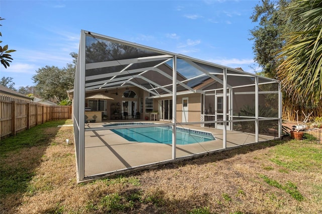 back of property featuring a lanai, a fenced in pool, and a patio