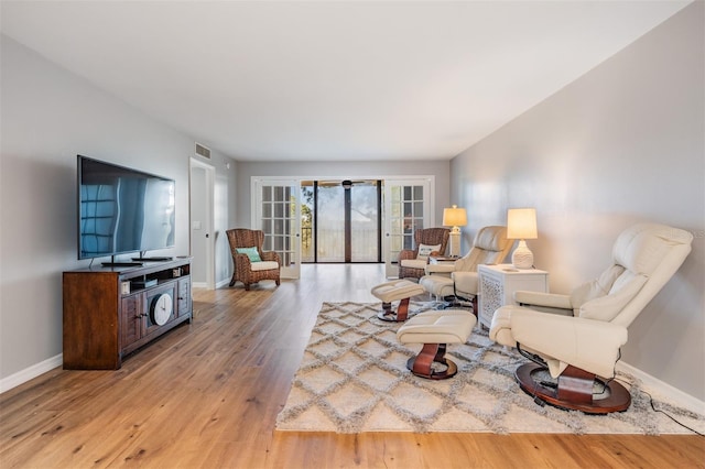 living room with french doors, visible vents, light wood-style flooring, and baseboards