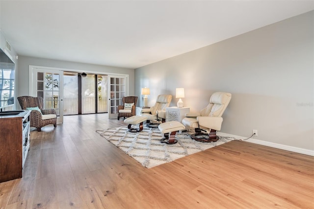 sitting room featuring a wealth of natural light, visible vents, baseboards, and hardwood / wood-style flooring