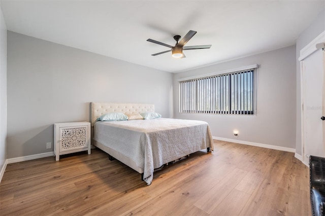 bedroom with ceiling fan, baseboards, and wood finished floors