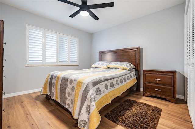 bedroom with a ceiling fan, baseboards, and light wood finished floors