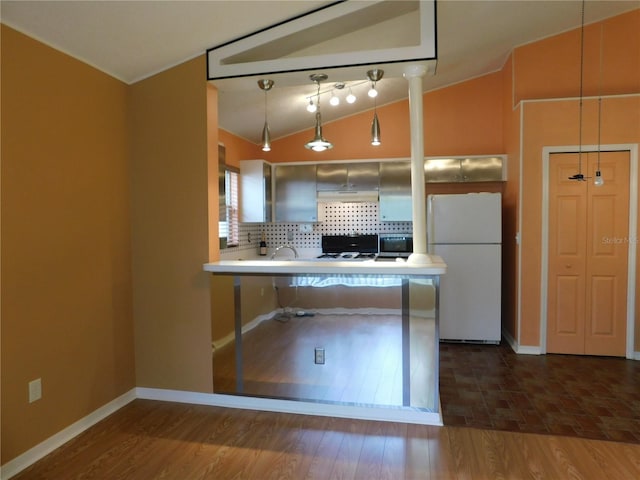 kitchen featuring dark wood-type flooring, backsplash, white refrigerator, vaulted ceiling, and kitchen peninsula