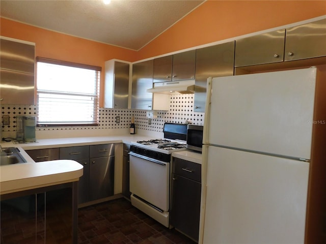 kitchen with white appliances, lofted ceiling, sink, and backsplash