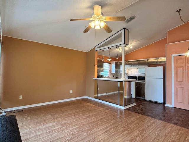 kitchen with lofted ceiling, ceiling fan, white refrigerator, hardwood / wood-style floors, and kitchen peninsula