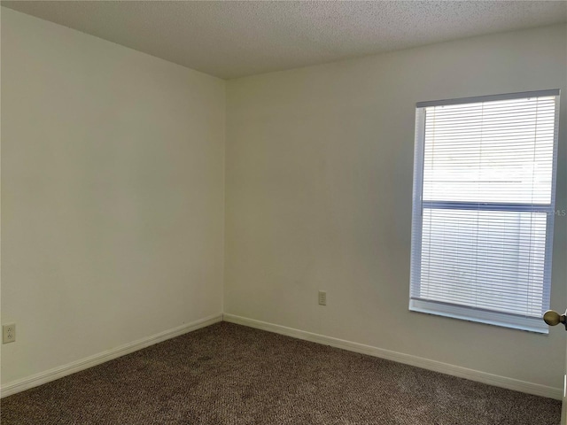 carpeted spare room featuring a textured ceiling