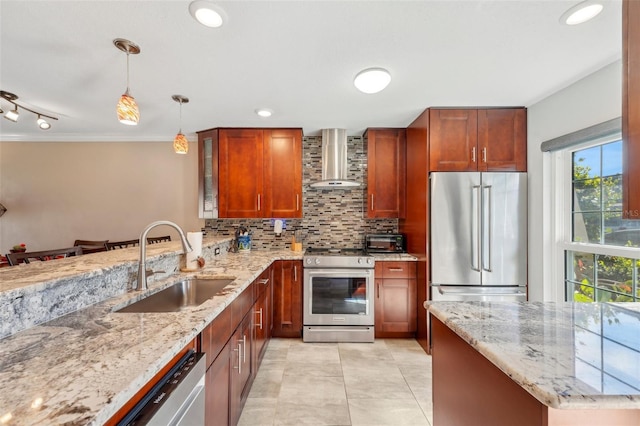 kitchen featuring stainless steel appliances, sink, wall chimney range hood, and light stone counters