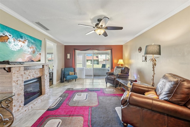 living room with light tile patterned flooring, a stone fireplace, crown molding, a textured ceiling, and ceiling fan