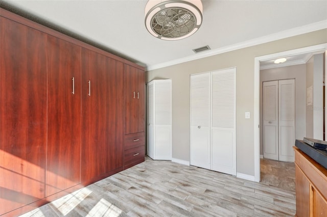 unfurnished bedroom featuring ornamental molding and light hardwood / wood-style flooring