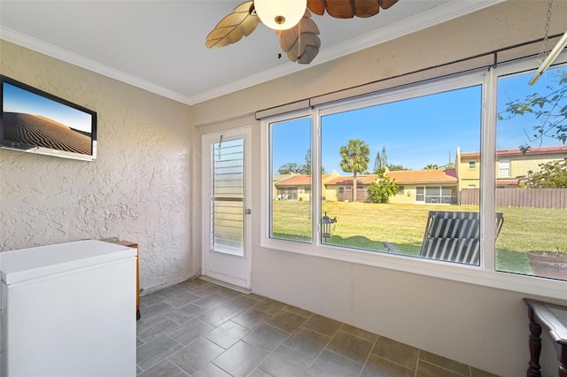 unfurnished sunroom with ceiling fan