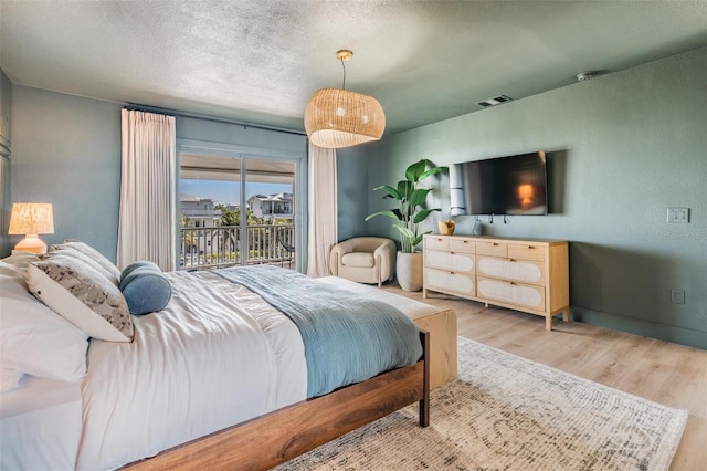 bedroom featuring hardwood / wood-style flooring and access to exterior