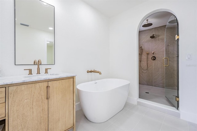 bathroom featuring tile patterned flooring, shower with separate bathtub, and vanity