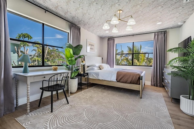 bedroom featuring light hardwood / wood-style flooring and a notable chandelier