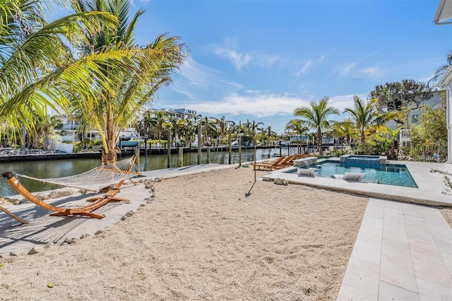 exterior space featuring a swimming pool with hot tub and a water view