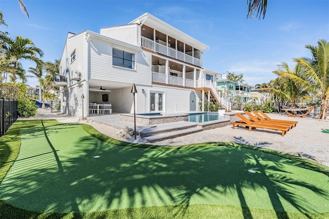 rear view of house featuring ceiling fan, a swimming pool with hot tub, a balcony, and a patio area