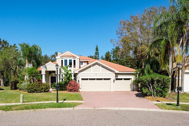 mediterranean / spanish home with a garage and a front yard