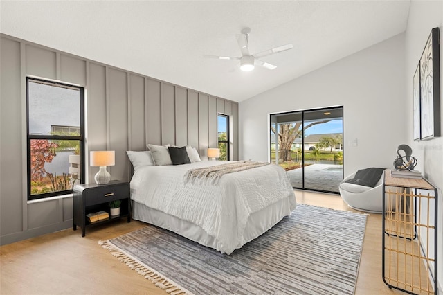 bedroom featuring ceiling fan, lofted ceiling, access to exterior, and light hardwood / wood-style flooring