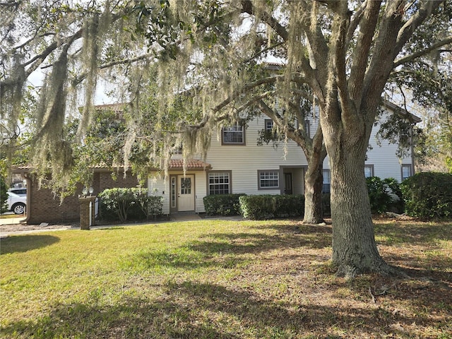 view of property hidden behind natural elements featuring a front lawn