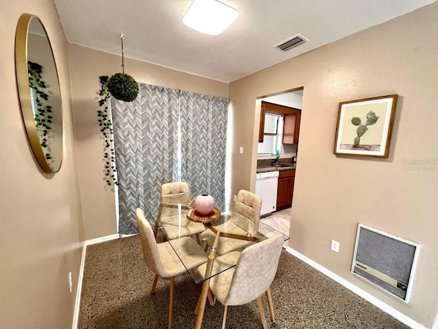 carpeted dining area featuring sink and heating unit