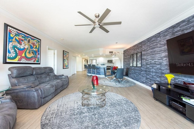 living room with ornamental molding, ceiling fan, and light wood-type flooring