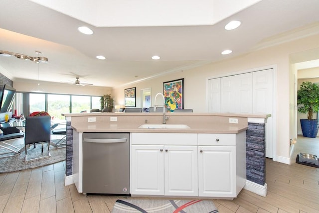 kitchen featuring dishwasher, sink, white cabinets, ornamental molding, and a center island with sink