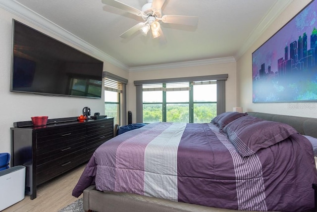 bedroom with ornamental molding, light wood-type flooring, and ceiling fan