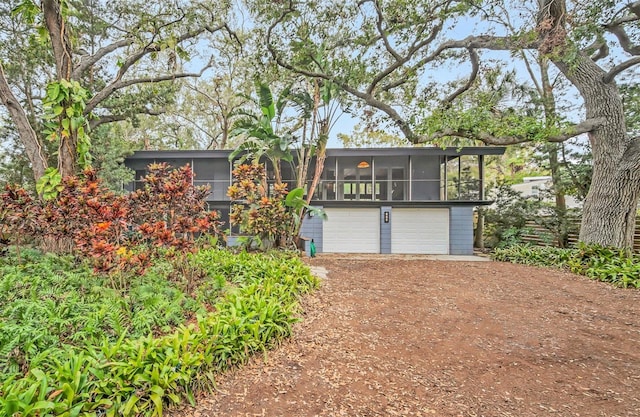 view of front of property with a garage and a sunroom