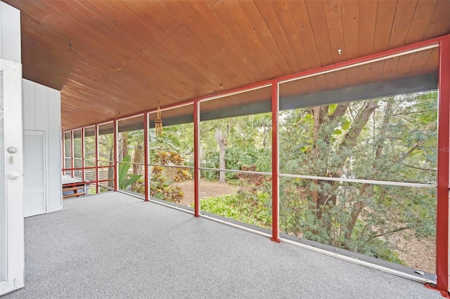 unfurnished sunroom with wood ceiling and a healthy amount of sunlight