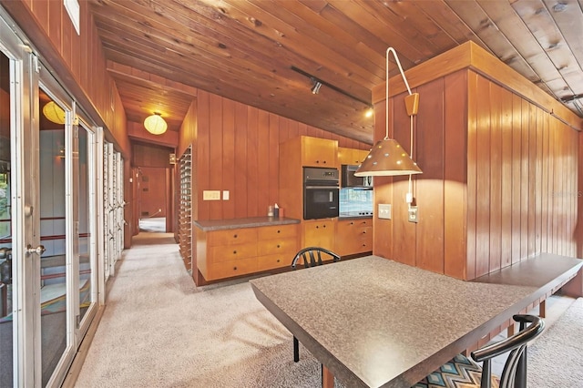 kitchen with pendant lighting, light colored carpet, black oven, and wooden ceiling