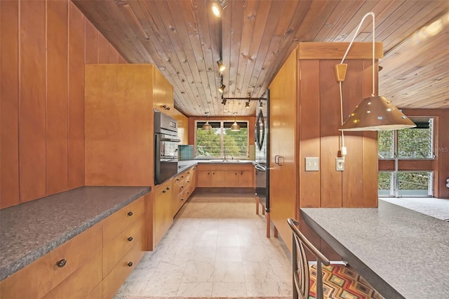 kitchen with rail lighting, oven, sink, and wooden ceiling