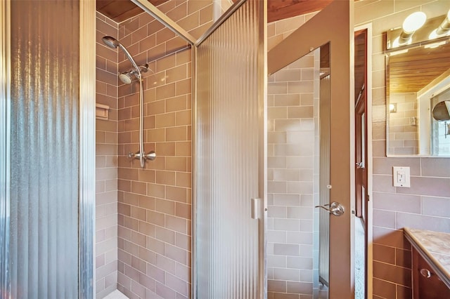 bathroom featuring vanity, tile walls, and a tile shower