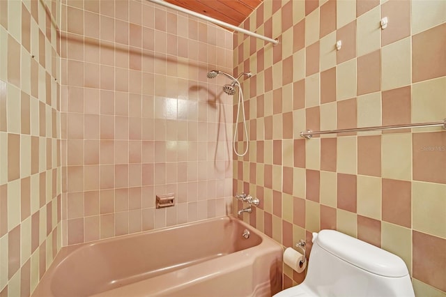 bathroom with toilet and tiled shower / bath combo