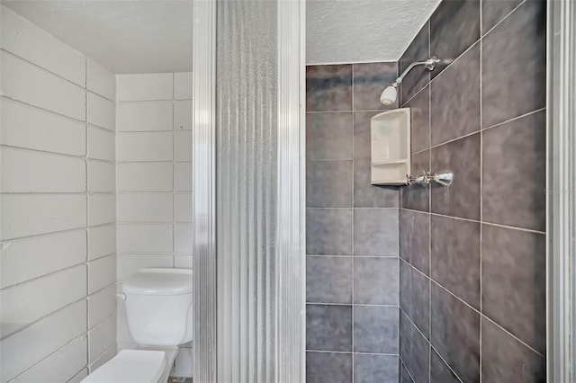 bathroom featuring walk in shower, tile walls, a textured ceiling, and toilet