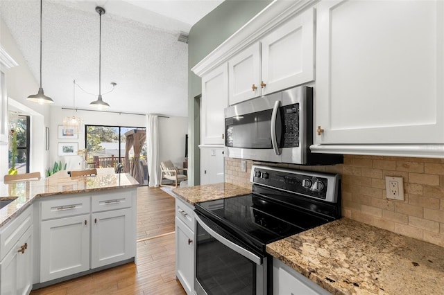 kitchen featuring light hardwood / wood-style flooring, appliances with stainless steel finishes, a textured ceiling, white cabinets, and decorative light fixtures