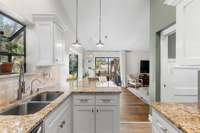 kitchen with pendant lighting, backsplash, dark wood-type flooring, and white cabinets