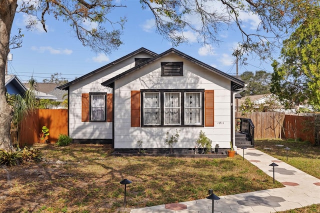 bungalow-style home featuring a front lawn