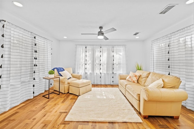 living room featuring ceiling fan and light hardwood / wood-style floors