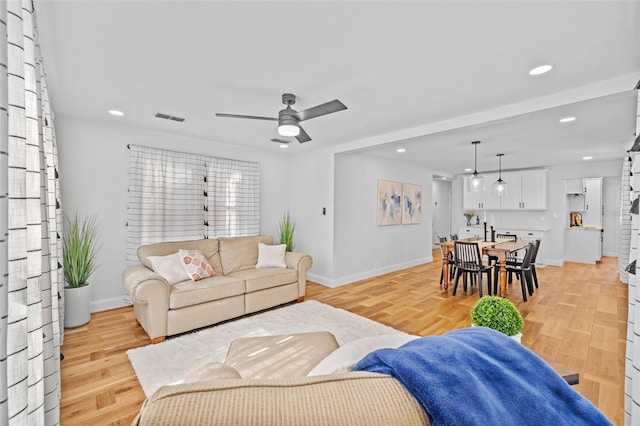 living room featuring light hardwood / wood-style floors and ceiling fan