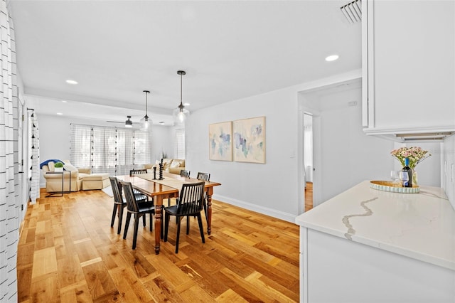 dining space with light hardwood / wood-style flooring and ceiling fan