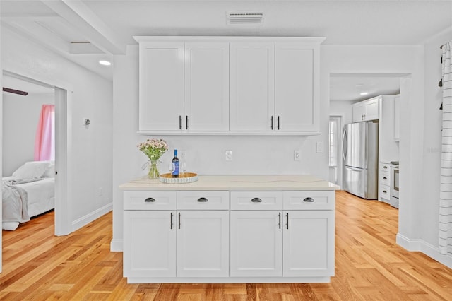 kitchen with light hardwood / wood-style floors, white cabinets, and appliances with stainless steel finishes