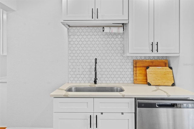 kitchen with backsplash, dishwasher, sink, and white cabinets