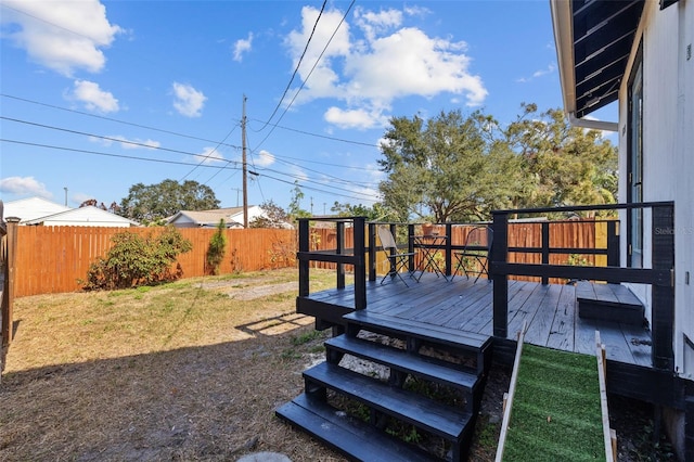 wooden deck featuring a lawn