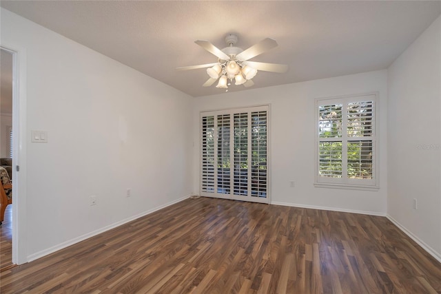 empty room with dark hardwood / wood-style floors and ceiling fan