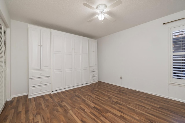 unfurnished bedroom featuring a textured ceiling, dark hardwood / wood-style floors, and ceiling fan