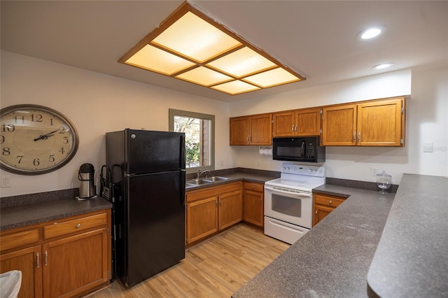 kitchen with light wood-type flooring, sink, and black appliances